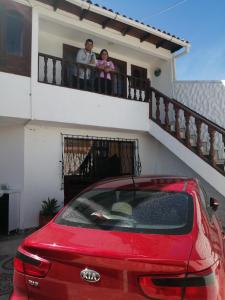 un homme et un enfant sur le balcon d'une maison dans l'établissement Hospedaje El Mirador, à Iza