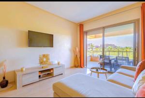 Camera con letto, TV e divano. di Marrakech golf city prestigia a Marrakech