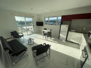 a living room with chairs and a table and a tv at AYDIZ APARTMENTS in Nadi
