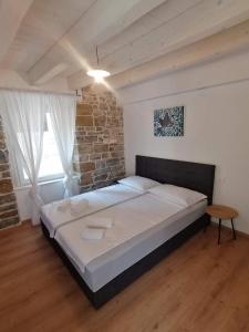 uma cama grande num quarto com uma parede de tijolos em GG art apartments II em Piran