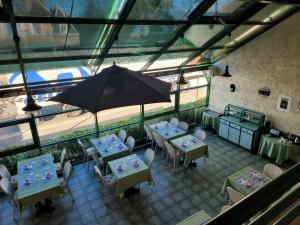 ドンピエール・シュル・ベズブルにあるL'AUBERGE DE L'OLIVEのテーブルと傘が備わるレストランの上から見える景色