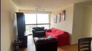 - un salon avec deux chaises et un canapé rouge dans l'établissement Departamento Huaca San Miguel, à Lima