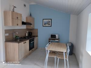 Gîtes des Colombières & Spa في Saint-Maixent-sur-Vie: مطبخ مع طاولة وكراسي في غرفة