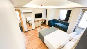 ein Schlafzimmer mit einem Bett, einem Sofa und einem TV in der Unterkunft Nira Boutique Hotel in Ankara