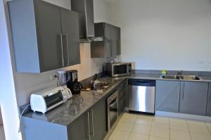 a kitchen with gray cabinets and a counter top at Condominio 8vo Piso, Jaco Bay in Jacó