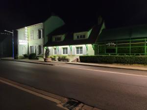 eine leere Straße in der Nacht mit einem weißen Gebäude in der Unterkunft L'AUBERGE DE L'OLIVE in Dompierre-sur-Besbre