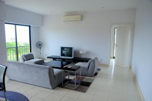 a living room with two couches and a television at Condominio 8vo Piso, Jaco Bay in Jacó
