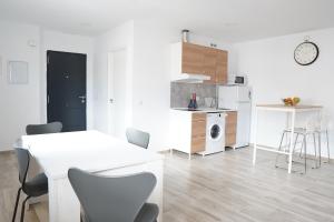 a white dining room with a white table and chairs at APARTAMENTOS TURÍSTICOS SAN MIGUEL ARCÁNGEL, S.L. in San Roque +20 photos