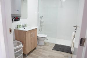 a white bathroom with a toilet and a sink at APARTAMENTOS TURÍSTICOS SAN MIGUEL ARCÁNGEL, S.L. in San Roque