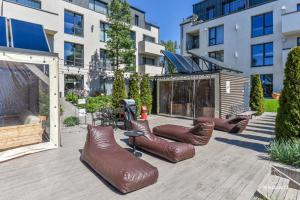 a patio with a bunch of brown leather chairs at Malūno vila 777 in Palanga