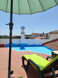 a chair and an umbrella next to a pool at Mansão Alentejana AL in Alvalade