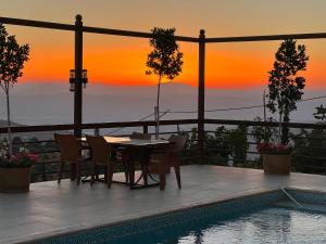 een patio met een tafel en stoelen naast een zwembad bij Sultana Farm - Private Pool Villa near Amman in Bayyūḑah +75 foto's