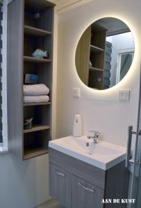a bathroom with a sink and a mirror at Zomerhuis "aan de kust" in Egmond aan Zee