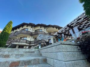 Un grand bâtiment avec des escaliers se trouve juste devant. dans l'établissement Family Hotel Eterno, à Tsigov Chark