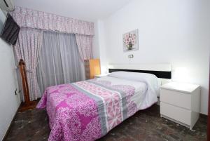 a bedroom with a bed with a pink and white blanket at BENIBEACH - Fincas Arena in Benidorm