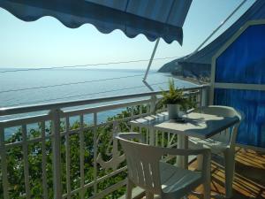 a table and chairs on a balcony with the ocean at Kastra in Velika