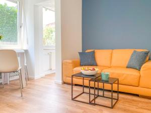 a living room with an orange couch and a table at Gemütliches Apartment mit Terrasse in ruhiger Lage in Kempten