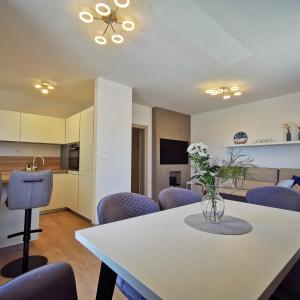 a dining room and kitchen with a table and purple chairs at Apartment Ližnjan in Ližnjan
