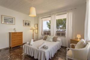 a white bedroom with a bed and a window at Bell Punt in Alcudia