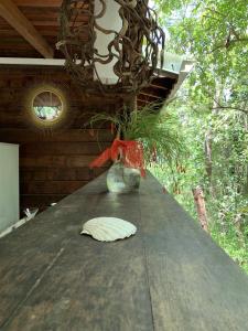 einen Holztisch mit einer Vase darüber in der Unterkunft mon Ecolodge Creole in Fort-de-France
