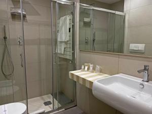 een badkamer met een wastafel en een glazen douche bij Viva Hotel Avellino in Avellino