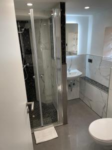 a bathroom with a shower and a toilet and a sink at Hotel Anker in Großenlinden