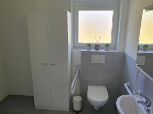 a bathroom with a toilet and a sink and a window at Studio "Minergy" in Donatyre