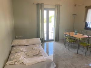 a bedroom with a bed and a table with chairs at Marko's Cozy Apartment in Megalochori