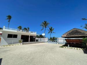 une maison blanche avec des palmiers en arrière-plan dans l'établissement Maykenn Beach, à Ocoy