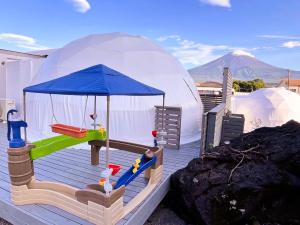 une maison igloo avec une pièce de jeu sur une terrasse dans l'établissement Necoana Glamping Annovillasグランピング, à Fujikawaguchiko