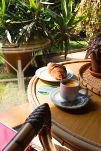 una mesa con una taza de café y una pastelería en Résidence Hôtelière les Acanthes, en Hossegor