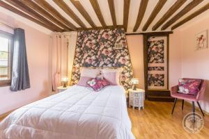 a bedroom with a large bed with pink pillows at Ferme du Vaucanu in Vimoutiers +8 photos