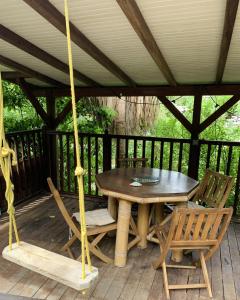 a wooden table and chairs on a porch at mon Ecolodge Creole in Fort-de-France +4 photos