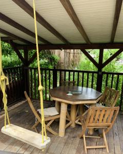 einen Holztisch und Stühle auf einer Veranda in der Unterkunft mon Ecolodge Creole in Fort-de-France