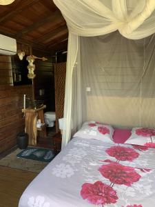 a bedroom with a bed with flowers on it at mon Ecolodge Creole in Fort-de-France