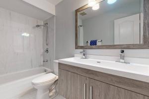 a bathroom with a sink and a toilet and a mirror at Cozy 3 bedroom townhouse near Canada's Wonderland! in Vaughan