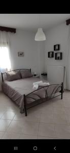 una camera da letto con un grande letto in una stanza bianca di Panos Luxury Suites a Kalabaka