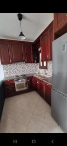 a kitchen with wooden cabinets and a stainless steel refrigerator at Panos Luxury Suites in Kalabaka