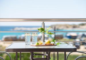 un tavolo con bicchieri d'acqua e frutta sopra di Marianna Studios a Kriaritsi
