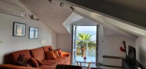 a living room with a couch and a view of the ocean at Penthouse by the Sea in Tivat
