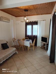 a dining room with a table and chairs and a tv at Iliadis Vacation Homes in Petalidi