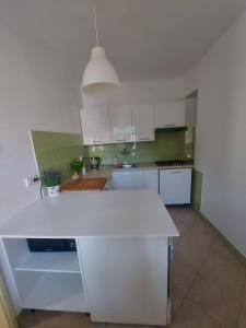 a kitchen with white cabinets and a white counter top at Apartment Iva Pula in Banjole +2 photos