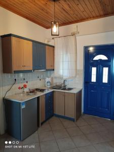 una cocina con armarios azules y una puerta azul en Iliadis Vacation Homes, en Petalidi