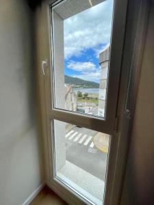 an open window with a view of the ocean at Precioso y acogedor apto. en Noia. Recién renovado in Noya