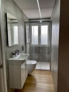 a bathroom with a toilet and a sink and a shower at Precioso y acogedor apto. en Noia. Recién renovado in Noya