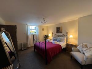 1 dormitorio con 1 cama con manta roja y silla en Anchor Hotel en Johnshaven