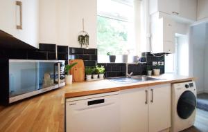 a kitchen with a sink and a microwave at The Mellor - Holiday Home 15 Mins to Central Manchester With Free Parking in Manchester