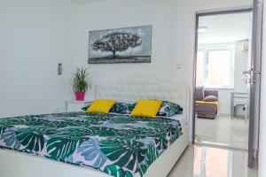 a bedroom with a bed with yellow pillows and a tree at Comfortable apartment near Opatija in Matulji