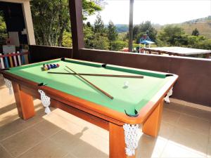a pool table with cue sticks on top of it at Pousada Valle das Colinas in Tiradentes