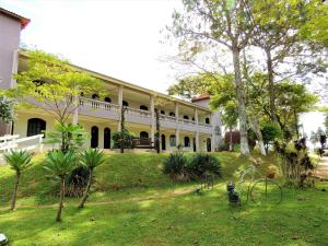 a building with a yard with a bike in the grass at Pousada Valle das Colinas in Tiradentes